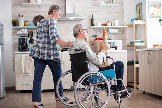 personne en fauteuil roulant dans une cuisine aménagée pour les PMR